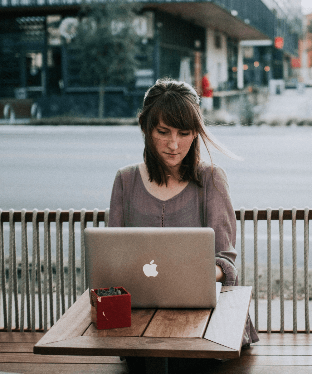 Woman on a laptop outside at a cafe